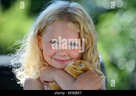 Kleines Mädchen mit blondem Haar und Kuscheltier, Porträt, Schweden Stockfoto