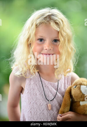 Kleines Mädchen mit blondem Haar und Kuscheltier, Schweden Stockfoto