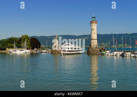 Ausflugsschiff im Hafen Eingang, zwischen Leuchtturm und Bayerischer Löwe, Lindau am Bodensee, Schwaben, Bayern, Deutschland Stockfoto