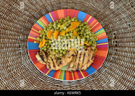 Grüne Erbsen mit Möhren und Gegrilltes Hähnchenfilet. Griechisches Essen. Stockfoto