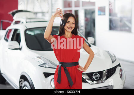 Lächelnd Autoverkäufer Übergabe ihres neuen Autoschlüssel, Ho und Vertriebskonzept. Happy girl der Käufer. Stockfoto