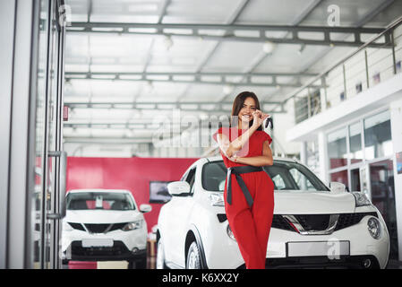 Lächelnd Autoverkäufer Übergabe ihres neuen Autoschlüssel, Ho und Vertriebskonzept. Happy girl der Käufer. Stockfoto