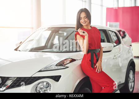 Lächelnd Autoverkäufer Übergabe ihres neuen Autoschlüssel, Ho und Vertriebskonzept. Happy girl der Käufer. Stockfoto