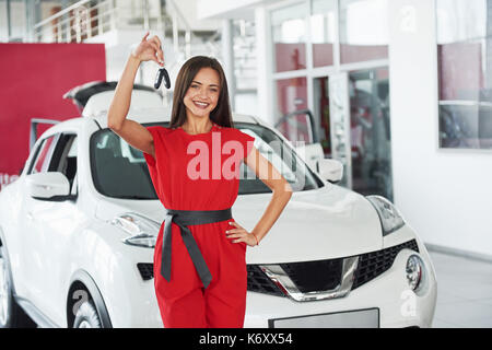 Lächelnd Autoverkäufer Übergabe ihres neuen Autoschlüssel, Ho und Vertriebskonzept. Happy girl der Käufer. Stockfoto