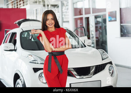 Lächelnd Autoverkäufer Übergabe ihres neuen Autoschlüssel, Ho und Vertriebskonzept. Happy girl der Käufer. Stockfoto