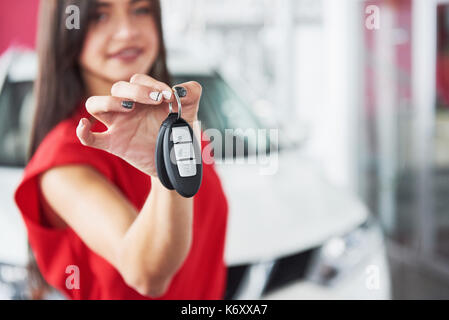 Lächelnd Autoverkäufer Übergabe ihres neuen Autoschlüssel, Ho und Vertriebskonzept. Happy girl der Käufer. Stockfoto