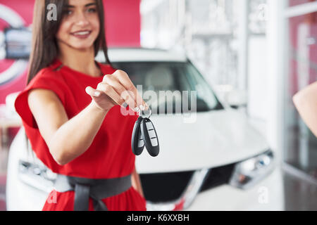 Lächelnd Autoverkäufer Übergabe ihres neuen Autoschlüssel, Ho und Vertriebskonzept. Happy girl der Käufer. Stockfoto