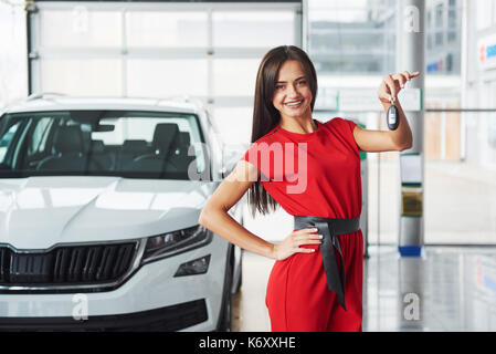 Lächelnd Autoverkäufer Übergabe ihres neuen Autoschlüssel, Ho und Vertriebskonzept. Happy girl der Käufer. Stockfoto
