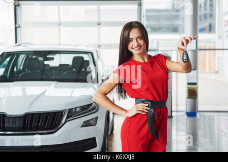 Lächelnd Autoverkäufer Übergabe ihres neuen Autoschlüssel, Ho und Vertriebskonzept. Happy girl der Käufer. Stockfoto