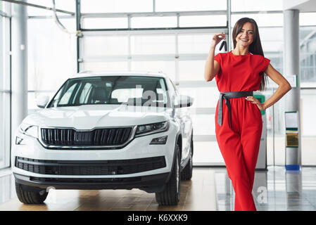 Lächelnd Autoverkäufer Übergabe ihres neuen Autoschlüssel, Ho und Vertriebskonzept. Happy girl der Käufer. Stockfoto