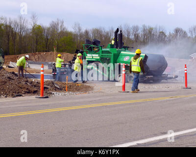 Crew über Asphalt mit einem Straßenfertiger. Stockfoto