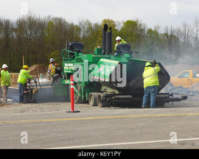 Crew über Asphalt mit einem Straßenfertiger. Stockfoto