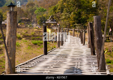 Handgefertigte lange Buddha Bambus Brücke über chemische Reisfeldern in der Nähe von touristischen Pai ich im Norden von Thailand. Asiatische Landschaft im Sommer. Stockfoto