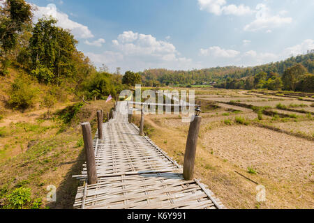 Handgefertigte lange Buddha Bambus Brücke über chemische Reisfeldern in der Nähe von touristischen Pai ich im Norden von Thailand. Asiatische Landschaft im Sommer. Stockfoto