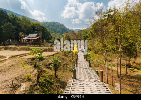 Handgefertigte lange Buddha Bambus Brücke über chemische Reisfeldern in der Nähe von touristischen Pai ich im Norden von Thailand. Asiatische Landschaft im Sommer. Stockfoto