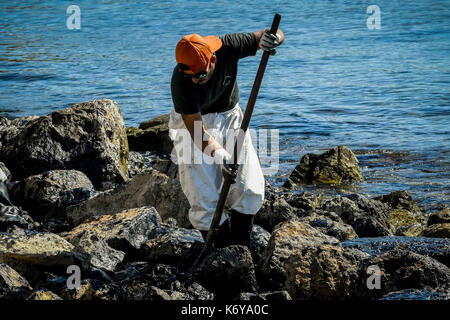 Salamis, Athen, Griechenland - Sept 13, 2017: Arbeitnehmer versuchen, Öl, das an Land gespült hat sauber, am Strand von Salamis Insel in der Nähe von Athen, nach einem alten ta Stockfoto