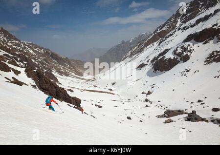 Marokko, Hoher Atlas, Skifahrer über Toubkal Hütte (3200m) nach dem Abstieg der Akioud (4000 m) Stockfoto