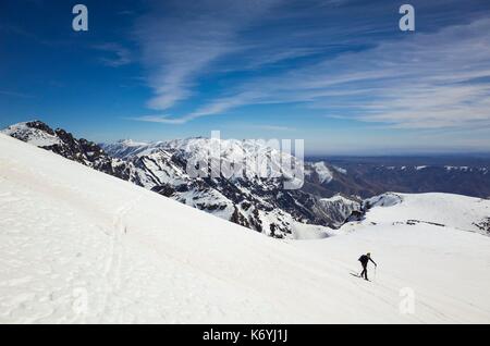 Marokko, Hoher Atlas, Skifahrer aufsteigend Ras-Ouanoukrim (4088 m), im Hintergrund Djebel Toubkal (4167 m) Stockfoto