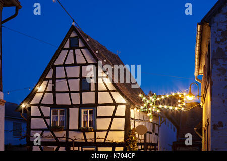 Fachwerkhäuser mit Weihnachtsbeleuchtung und Nacht blauer Himmel in Haines, Edenkoben, Deutschland. Stockfoto