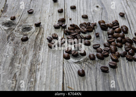 Geröstete Kaffeebohnen Stapel von oben auf einem rustikalen Holzmöbeln Hintergrund Stockfoto