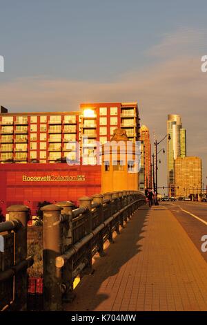 Die untergehende Sonne spiegelt sich Windows in ein flaches Gebäude und glänzt auf der Brücke, Turm und Brücke auf Chicagos Roosevelt Road. USA. Stockfoto