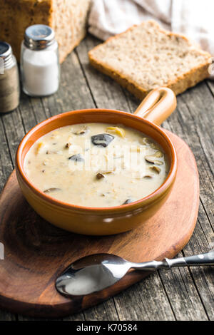 Creme von Pilz Suppe in der Schüssel auf alten Holztisch. Stockfoto