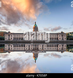 Dublin Custom House mit hellen orange Wolken und Reflexion in den Fluss Liffey in Dublin, Irland Stockfoto