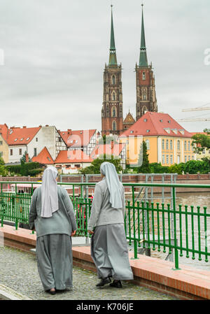 Zwei Nonnen entlang Wyspa Piasek mit der Kathedrale St. Johannes der Baptiste im Hintergrund, Ostrow Tumski 2017, Wroclaw, Polen Stockfoto