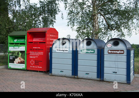 Recycling bins aufgereiht in einem kleinen Dorf in Deutschland; Glas wird in Klar, Grün und Braun getrennt. Stockfoto