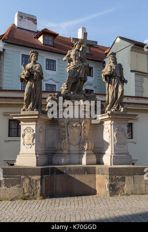 Statue des Heiligen Erlösers mit Cosmas und Damian auf der Nordseite der Karlsbrücke (Karluv most) in Prag, Tschechische Republik, an einem sonnigen Tag. Stockfoto