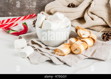 Traditionelle weihnachtliche Süßigkeiten - Candy Cane, Eibisch und gebacken auf Feuer marshmallow Spieße auf weißem Hintergrund, kopieren Raum Stockfoto