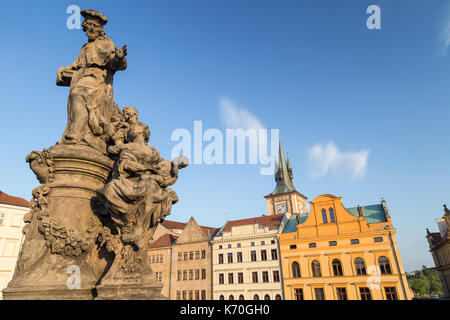 Statue von Ivo von Kermartin auf der südlichen Seite der Karlsbrücke (Karluv most) und Gebäude in der Altstadt von Prag, tschechische Republik, an einem sonnigen Tag. Stockfoto