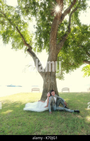 Foto von Vor Hochzeit Asiatische Paare unter einem Baum in einem Blumengarten im Konzept der Beginn einer Partnerschaft leben und Familie. Stockfoto