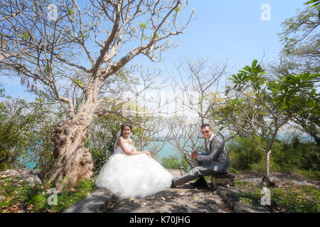 Foto von Vor Hochzeit Asiatische Paare unter einem Baum in einem Blumengarten im Konzept der Beginn einer Partnerschaft leben und Familie. Stockfoto