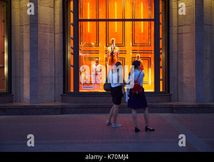 Kiew, Ukraine - September 04, 2017: Zwei junge Frauen getragen weiße Hemden und dunklen Röcke stehen auf bürgersteig vor Central Department Store (TSU Stockfoto