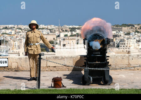Eine junge gunner Brände Maltas 12.00 Uhr Kanone der Mittagshitze Stunde zu markieren. Die 12:00 Uhr gun Salute ist eine alte Tradition, dass der Marine wurde im Jahr 2004 gegründet und Oc Stockfoto