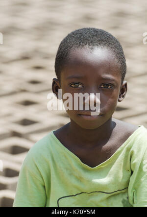 Vertikaler African black boy vor einer Menge Steine - Kinderarbeit arbeit Konzept - Nutzung Stockfoto