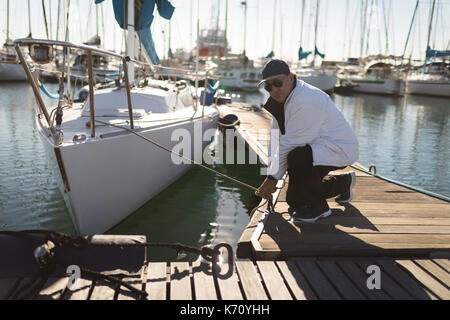 Yachtsman binden Seil am Pier, an einem sonnigen Tag Stockfoto