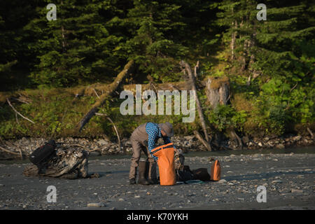 Mann mit Gepäck am Ufer gegen Bäume Stockfoto