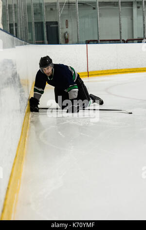 Bestimmt männliche Spieler spielt Eishockey an der Eisbahn Stockfoto