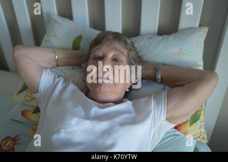 Ältere Frau schläft auf dem Bett im Schlafzimmer zu Hause Stockfoto