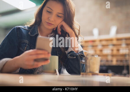 Schöne Frau mit Handy in CafÃƒÂ © Stockfoto
