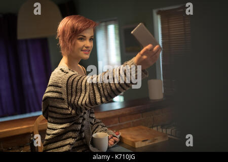 Junge Frau von selfie von Handy zu Hause Stockfoto