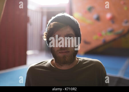 Portrait von zuversichtlich männlichen Athleten mit Stricken hat, während in der Turnhalle sitzen Stockfoto