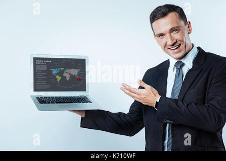 Freudige Geschäftsmann zum Bildschirm des Laptop zeigen Stockfoto