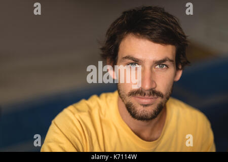 Hohen winkel Portrait von zuversichtlich männlichen Athleten in der Turnhalle sitzen Stockfoto