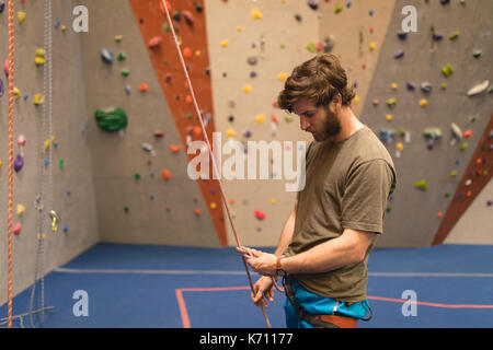 Seitenansicht des männlichen Athleten Kletterwand in der Turnhalle Stockfoto