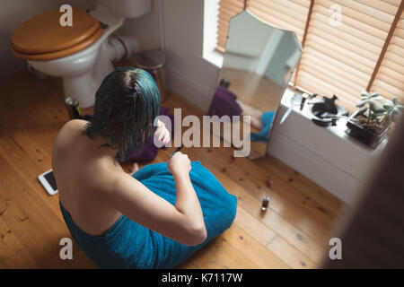 Hohe Betrachtungswinkel und der jungen Frau mit gefärbten Haaren durch die Fenster im Bad Stockfoto