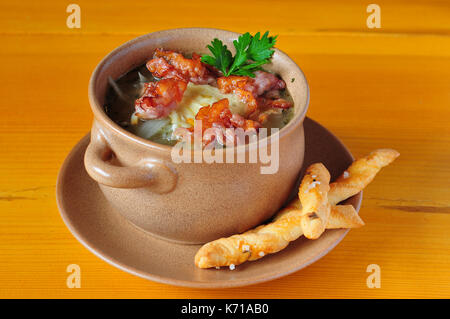 Zwiebelsuppe in Ton Schüssel mit Speck, Petersilie und Brot Finger Stockfoto