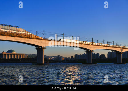 Seoul, Republik Korea - 24.10.2015: Grüne Linie der U-Bahn Brücke über den Fluss Han, mit Gebäude der Nationalversammlung auf den Hintergrund, Seoul. Stockfoto